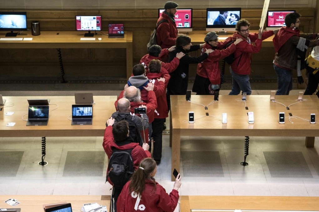 Activists stage a protest against alleged tax evasion by US multinational technology company Apple at a store in Paris. Photo: AFP