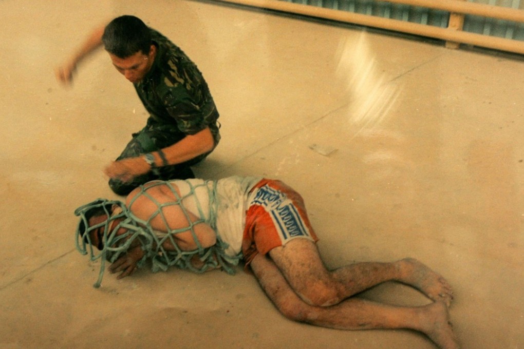A picture released by a British Court Martial in 2005 shows Lance Corporal Mark Cooley with an Iraqi detainee. Cooley and other UK soldiers were convicted and jailed for the mistreatment. Photo: AP