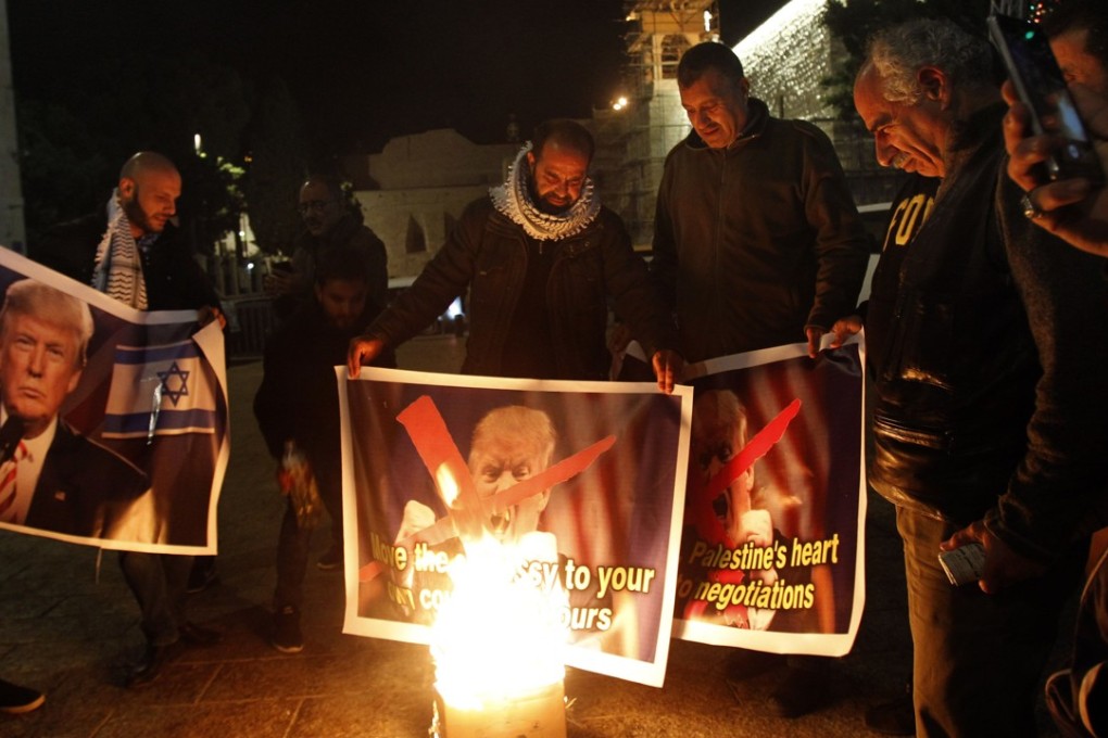Palestinian protesters burn pictures of US president Donald Trump at the manger square in Bethlehem on Tuesday. Photo: Agence France-Presse