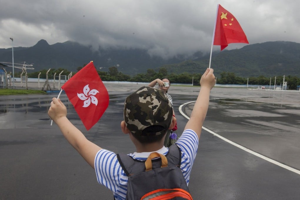 A child waves a Hong Kong flag and Chinese flag at the People's Liberation Army Shek Kong Barracks in Hong Kong during an open day. Photo: EPA