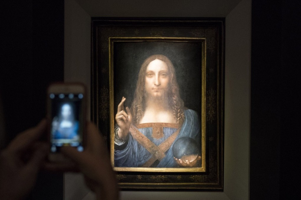 A visitor takes a photo of the painting Salvator Mundi by Leonardo da Vinci at Christie’s New York Auction House on November 15. Photo: Agence France-Presse
