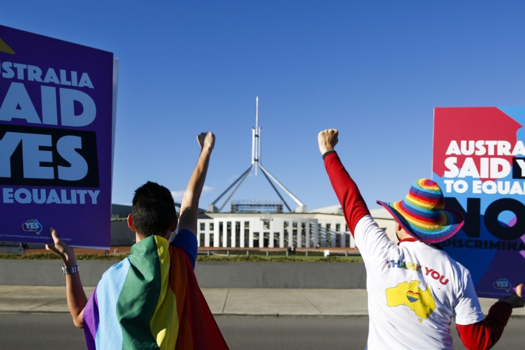 Equality ambassadors and volunteers from the Equality Campaign celebrate in front of Parliament House in Canberra ahead of the parliamentary vote on same sex marriage, which was passed. Photo: AFP