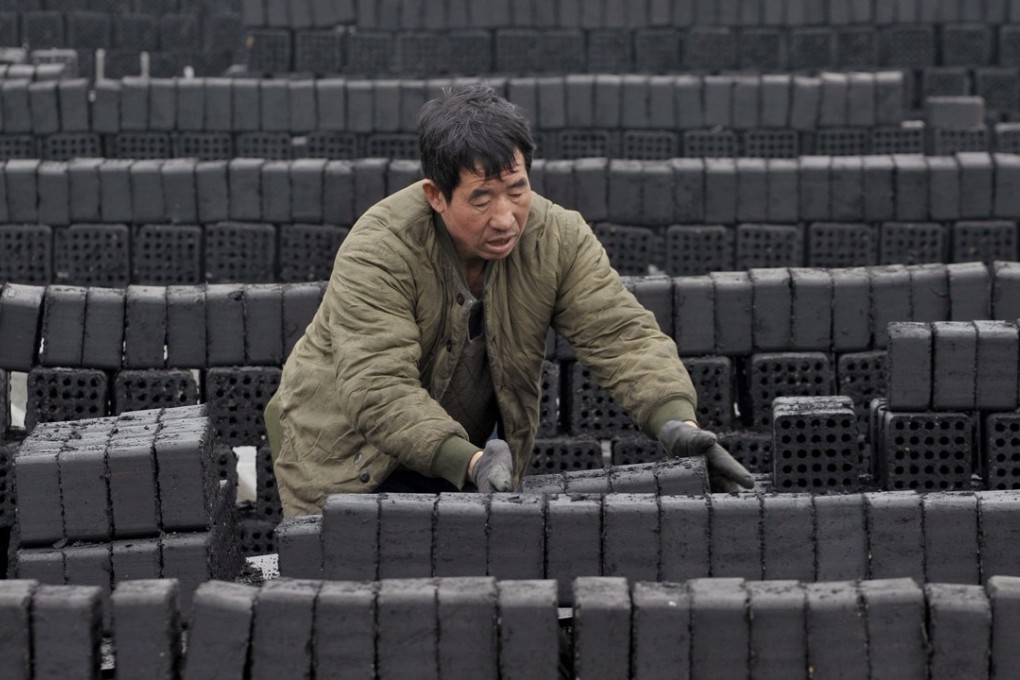 A worker prepares coal briquettes at a plant in Shenyang in northeastern China. Photo: EPA