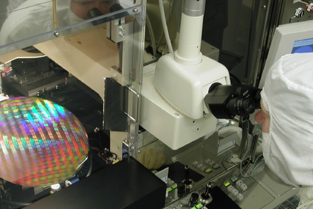 An Intel Corp technician looks through a microscope as he inspects a silicon wafer. Four former engineers of Applied Materials were charged in the US in a plot to steal chip designs and sell them to a Chinese start-up. Photo: AP