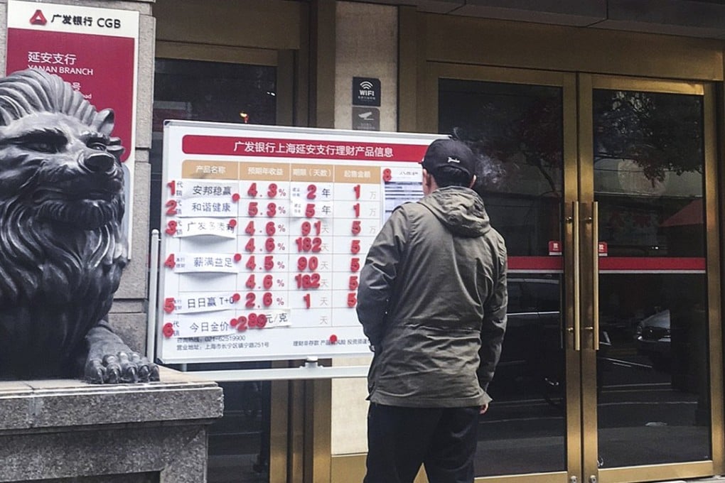 A passer-by looks at the advertisement of a universal insurance policy and other wealth management products sold by Anbang Group at a China Guangfa Bank outlet in Shanghai. Photo: SCMP