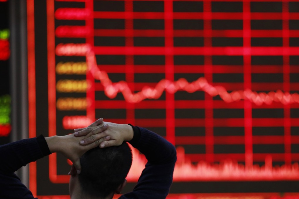 A broker looks at an electronic board showing stock market movements at a securities brokerage in Beijing, China. Photo: EPA