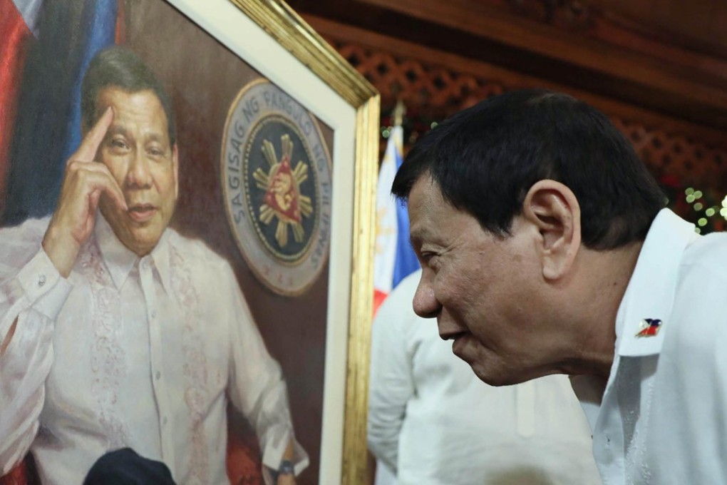 Philippine President Rodrigo Duterte viewing a gift of his portrait. The Philippine military has asked Duterte to extend martial law in southern Mindanao island. Photo: EPA-EFE