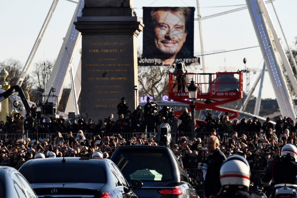 Late French singer Johnny Hallyday’s coffin is driven down the Champs-Elysees in Paris past tens of thousands of fans. Photo: AFP