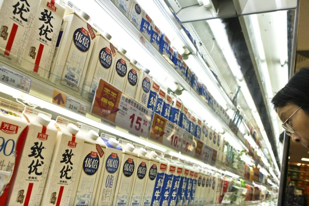 In this photo taken June 28, 2012, a customer checks dairy products made by Bright Dairy and Food Co. in a supermarket in Shanghai. Photo: AP