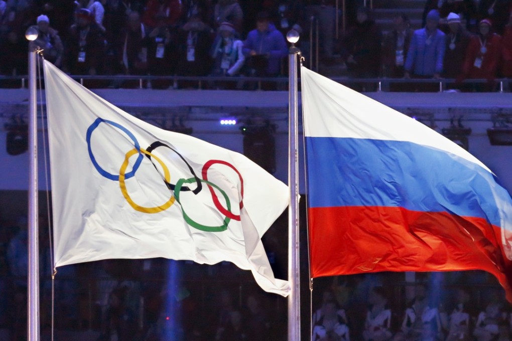The Olympic flag flying alongside the Russian flag at the 2014 Winter Olympics opening ceremony in Sochi. Photo: Kyodo