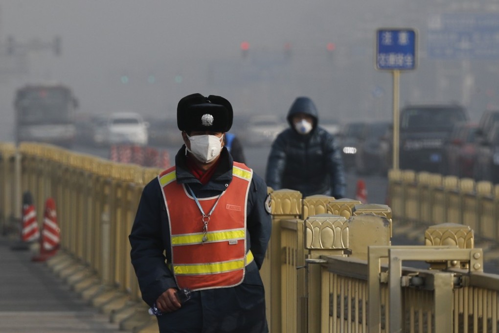 A traffic warden wears a mask to protect against the smog near Tiananmen Square in Beijing last month. Photo: AP