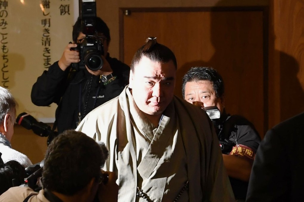 Sumo grand champion Harumafuji (C) leaves a press conference where he announced his retirement and apologised for the incident in which he injured a young wrestler. Photo: Kyodo