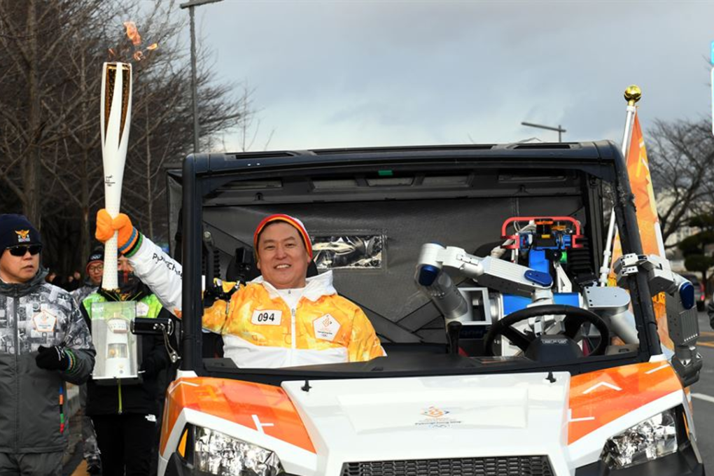 HUBO in the self-driving car with Professor Dennis Hong as a passenger during the torch relay in Daejeon. Photo: Yonhap