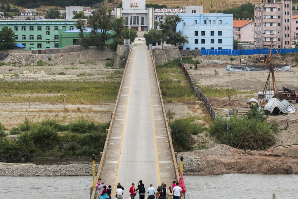 Chinese tourists stand watch on Tumen bridge linking China and North Korea, as seen from Yanbian, Jilin province. Photo: AP