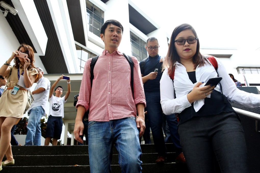 Civil rights activist Jolovan Wham (centre) leaves court after a hearing in Singapore on November 29, after being charged in relation to organising protests. Photo: Reuters