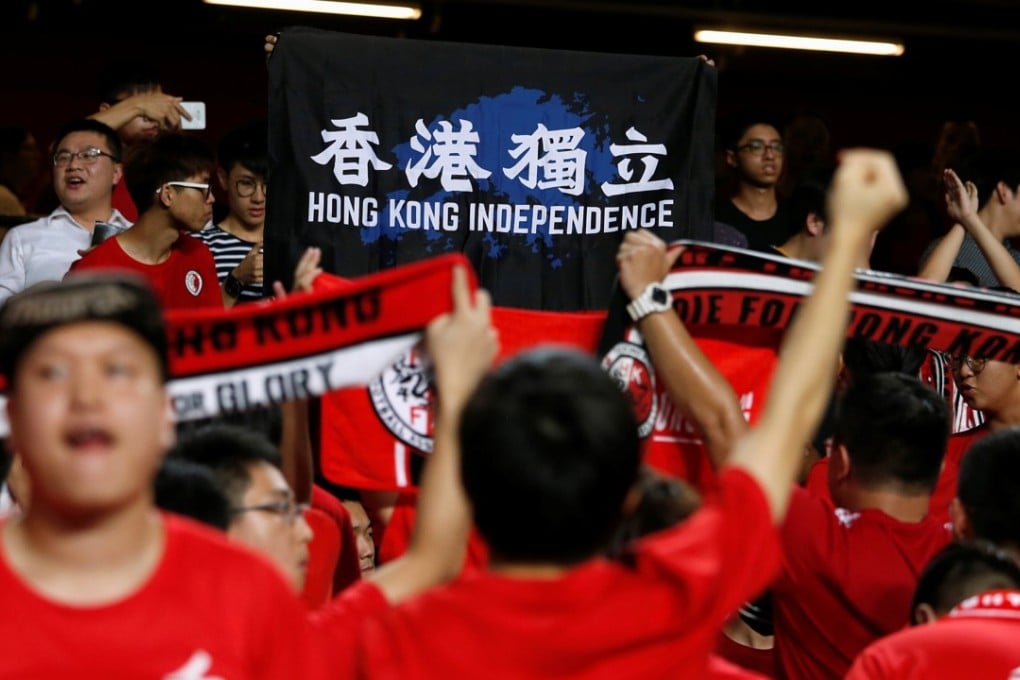 Hong Kong fans hold a protest banner and turn their backs while the Chinese national anthem played during Hong Kong’s football match against Malaysia in October. Photo: Reuters