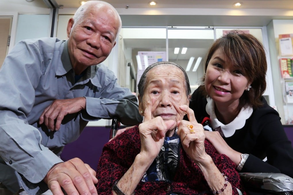 Two senior citizens pose for a picture with social worker Maggie Man at the ICFG Lung Hang Church Elderly Centre in Sha Tin in 2015. The government’s lump-sum grant funding system is designed to encourage welfare agencies to build community partnerships to address social problems effectively. Photo: David Wong