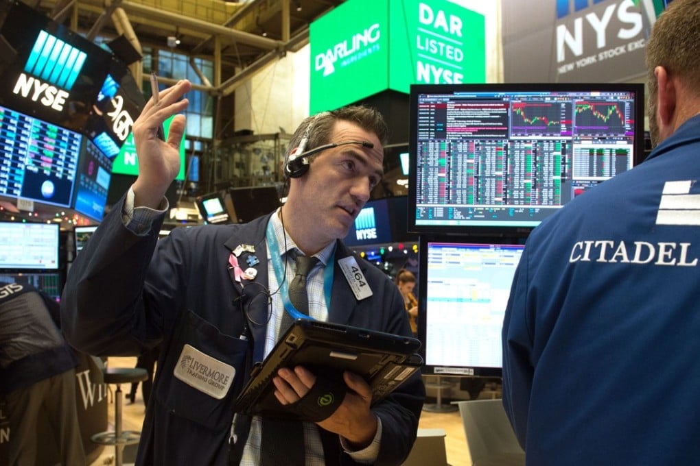 Traders at the New York Stock Exchange on December 13, 2017 in New York. The Dow finished at another record Wednesday as the Federal Reserve lifted interest rates and a major US tax cut bill in Congress moved closer to the finish line. At the closing bell, the Dow Jones Industrial Average was at 24,591.91, up 0.4 per cent, its fourth straight record close. Photo: AFP