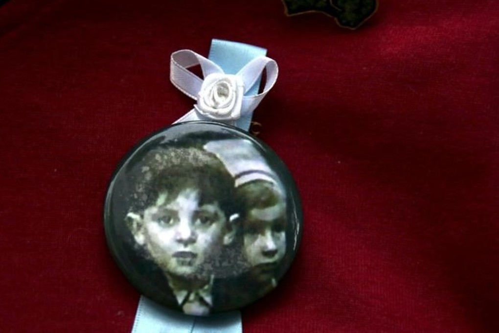 A relative wears a pin displaying a photograph of children who he said had been sexually abused by the Catholic Church. Photo: Reuters