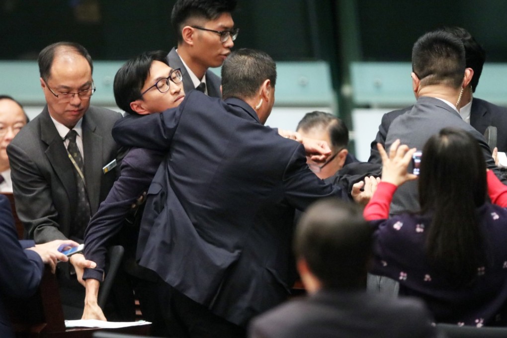 Lawmaker Eddie Chu Hoi-dick being carried out of the Legco chamber. Photo: Felix Wong