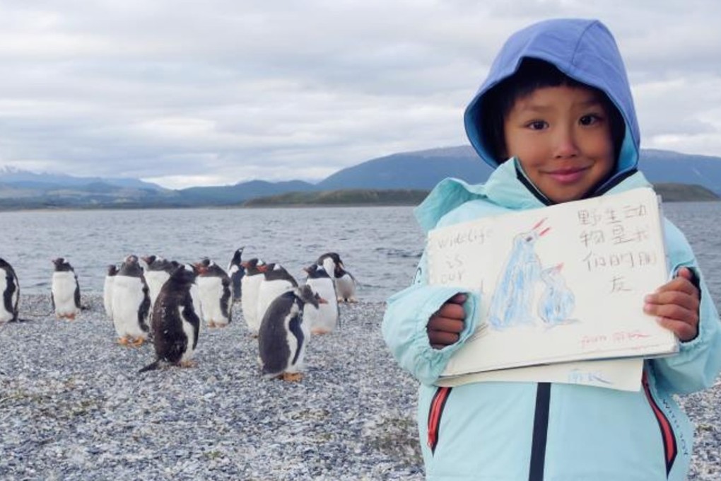 Simba poses with his drawing and penguins in Antarctica, hoping to raise people’s awareness of the need to protect the environment. Photo: Xu Chenghua