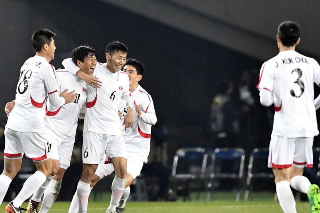 North Korea's forward Jong Il-gwan celebrates with his teammates after scoring the equaliser against China during the East Asian Championship draw. Photo: EPA