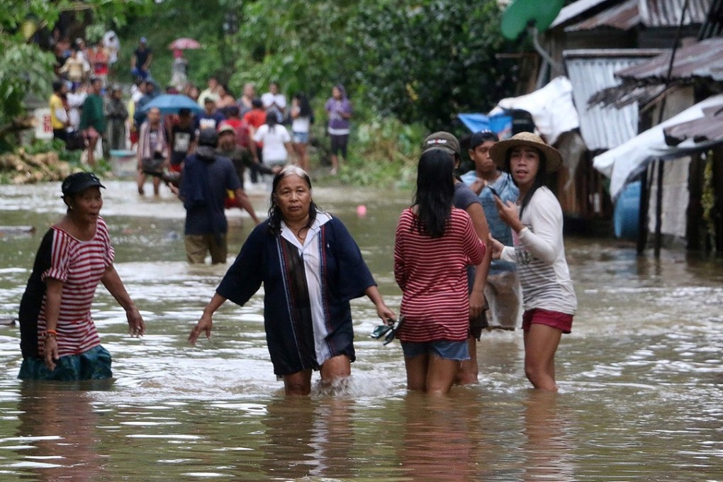 People wade through a flooded street in a village in Borongan on eastern Samar in the central Philippines. Photo: AFP