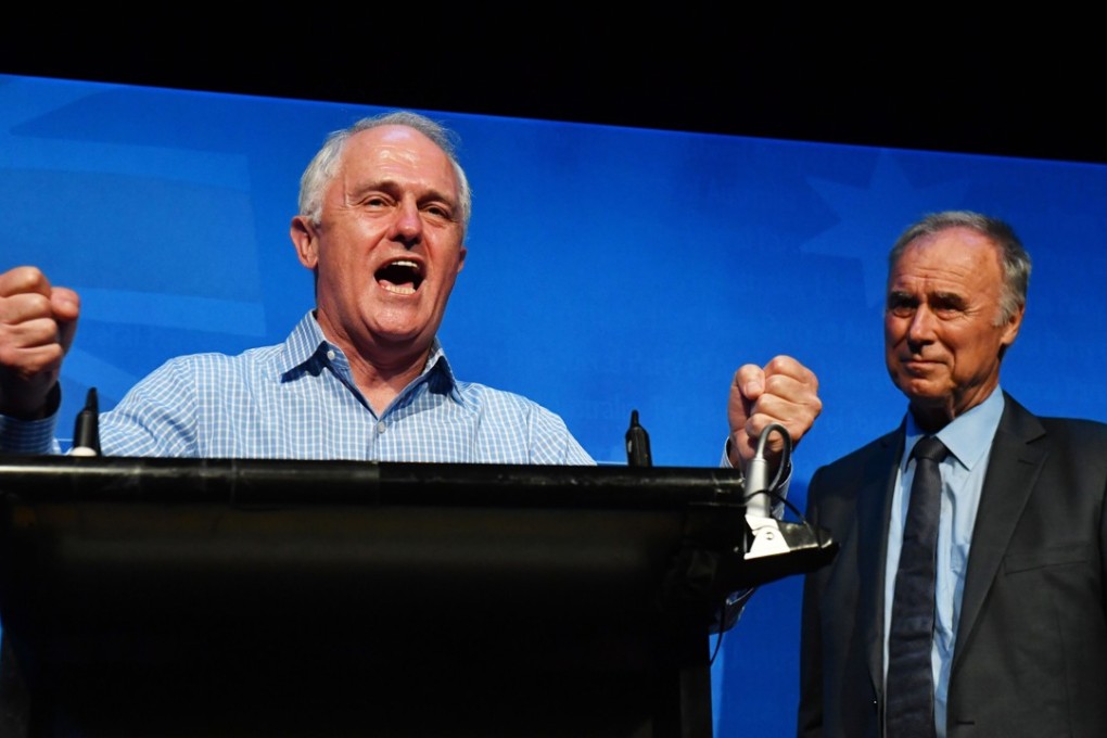 New Liberal member for Bennelong John Alexander watches Australian Prime Minister Malcolm Turnbull celebrate the by-election victory at the West Ryde Leagues Club. Photo: EPA