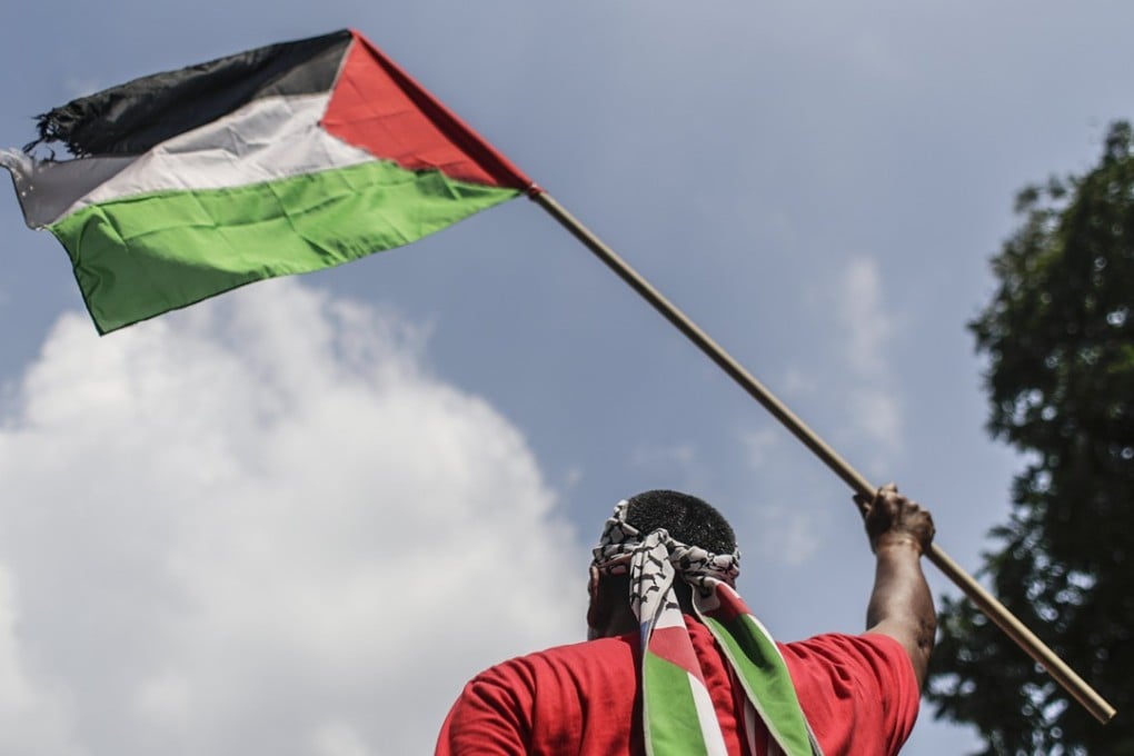 A protester with the Palestinian flag marches in Kuala Lumpur. Photo: EPA