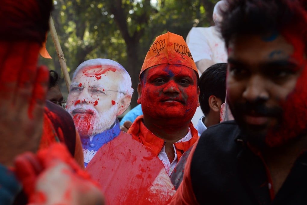 A Supporter of India's ruling Bharatiya Janata Party (BJP) looks on as he celebrates outside the party headquarters in New Delhi, with early counting of votes indicating a comfortable win for them in the key states of Gujarat and Himachal Pradesh. Photo: AFP