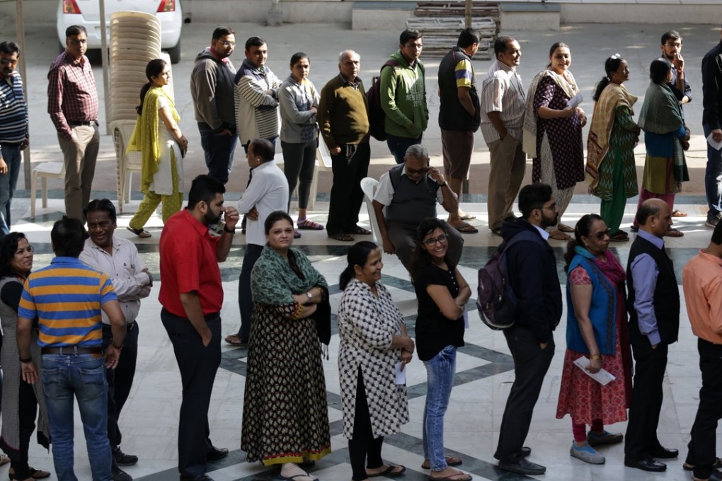 Voters wait in a long queue to cast their votes at a polling station during the second phase of Assembly election of Gujarat state. Photo: EPA