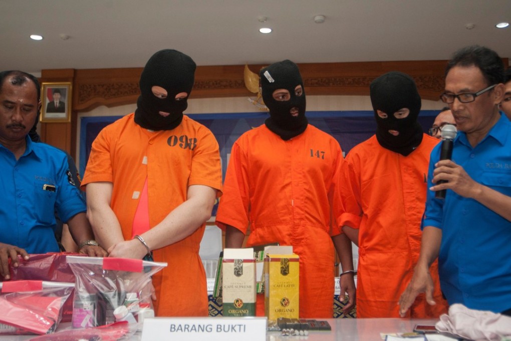 Anti-Narcotics Agency officials present an Australian man (2nd L), an American man (C), and a Malaysian man (2nd R) to reporters after they were arrested for carrying illegal drugs at Ngurai Rai airport in Denpasar, Bali. Photo: Reuters