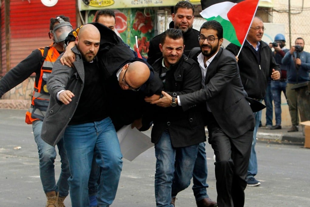 Palestinian protesters carry a man, wounded by a rubber bullet, following a demonstration in Bethlehem on December 13 over US President Donald Trump’s recognition of Jerusalem as Israel’s capital. Photo: Agence France-Presse