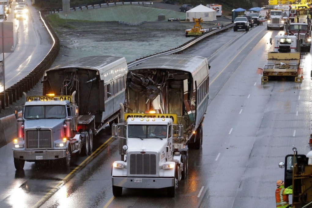 Two damaged train carriages are removed from the scene of an Amtrak train crash onto Interstate 5 on Tuesday in DuPont, Washington. Photo: AP