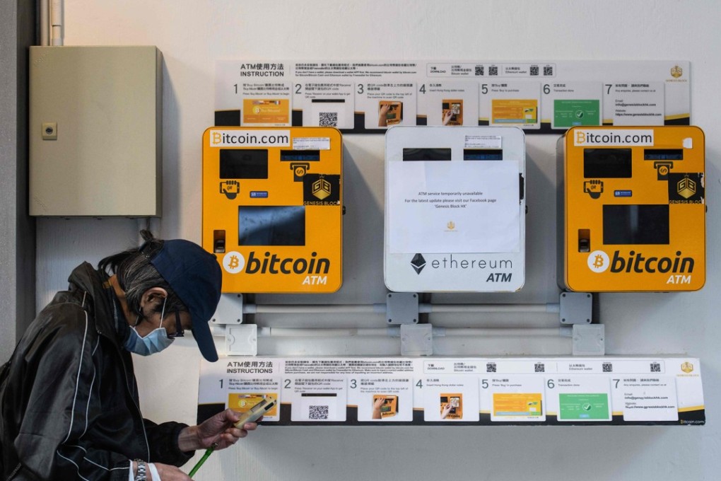 A man uses his phone as he walks past ATM machines for digital currency bitcoin in Hong Kong on December 18, 2017. Bitcoin has soared in recent weeks, breaking numerous records, and has risen more than 20-fold since the start of 2017. Photo: AFP