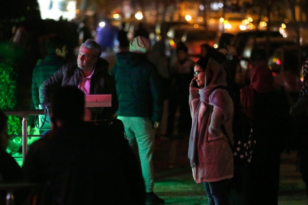 People phone and wait in the streets in Tehran on December 21, 2017, after an earthquake was felt in the Iranian capital. The quake measuring 5.2 magnitude struck before midnight local time. Photo: AFP
