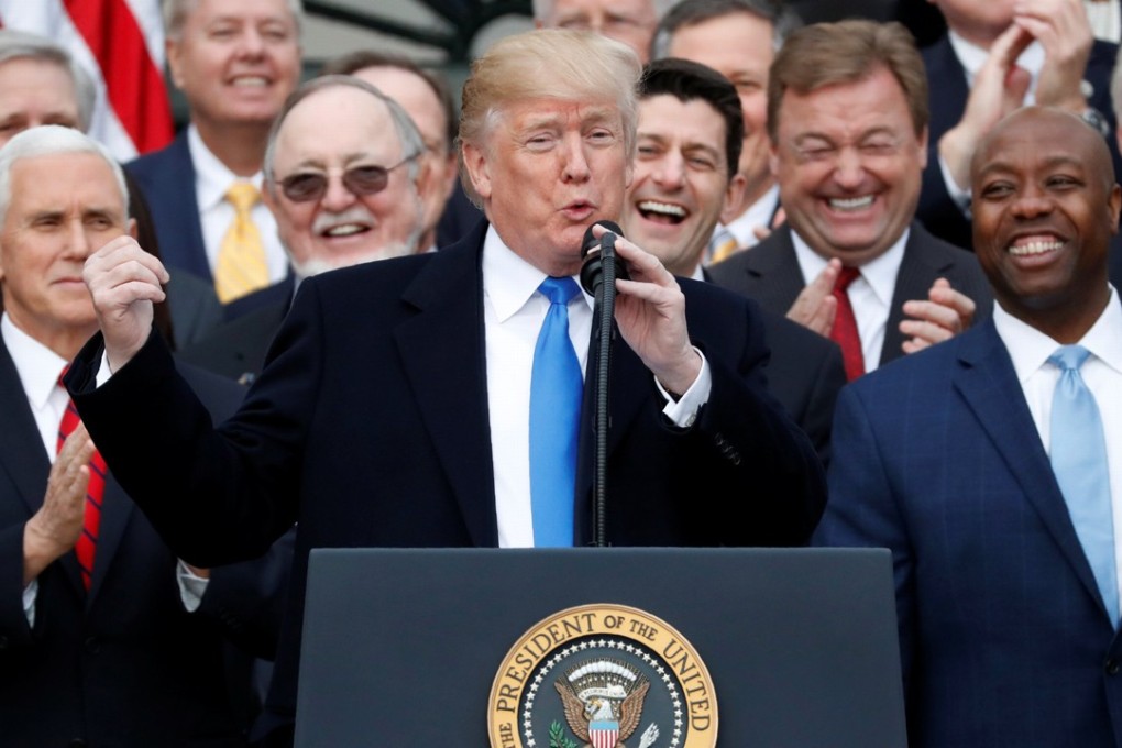 President Donald Trump celebrates with Vice-President Mike Pence (far left), House Speaker Paul Ryan (fourth right) and congressional Republicans, after the US Congress passed sweeping tax overhaul legislation, at the White House on December 20. Photo: Reuters