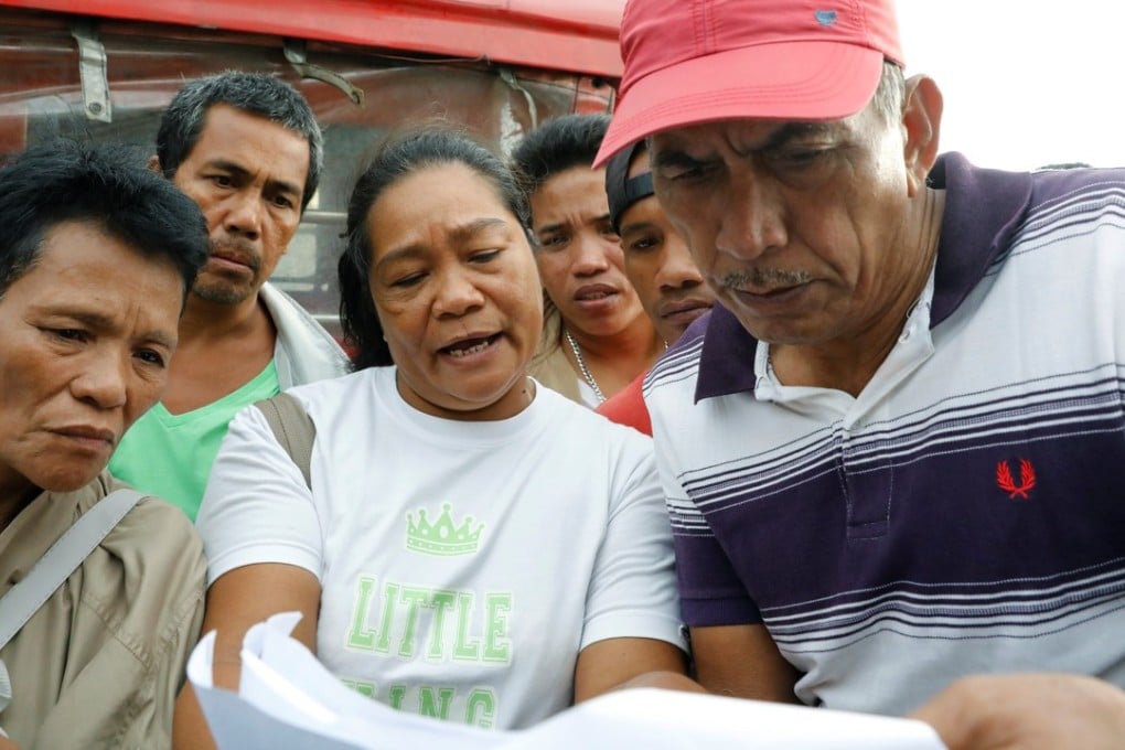 Filipinos look for their missing relatives on a list of survivors after the ferry capsized. Photo: Reuters