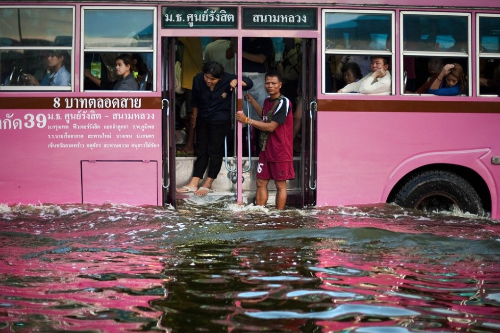 A bus drives through floodwaters in central Bangkok. Photo: AFP