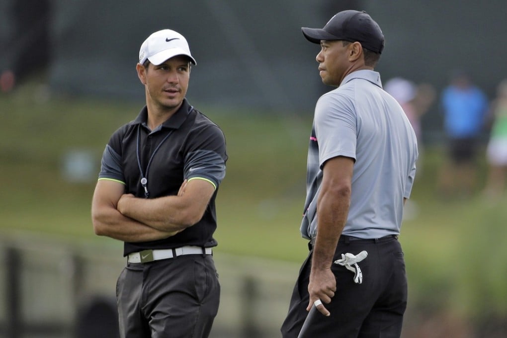 Tiger Woods, right, talks with swing coach Chris Como on the 17th green during a practise round for The Players Championship golf tournament at Sawgrass in Ponte Vedra Beach, Florida. The two have parted ways. Photo: AP