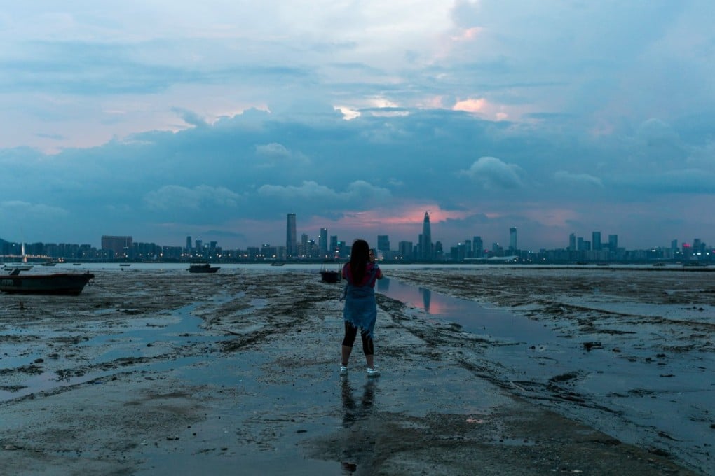 A woman looks at the city of Shenzhen across Deep Bay at Hong Kong’s Lau Fau Shan. Photo: EPA