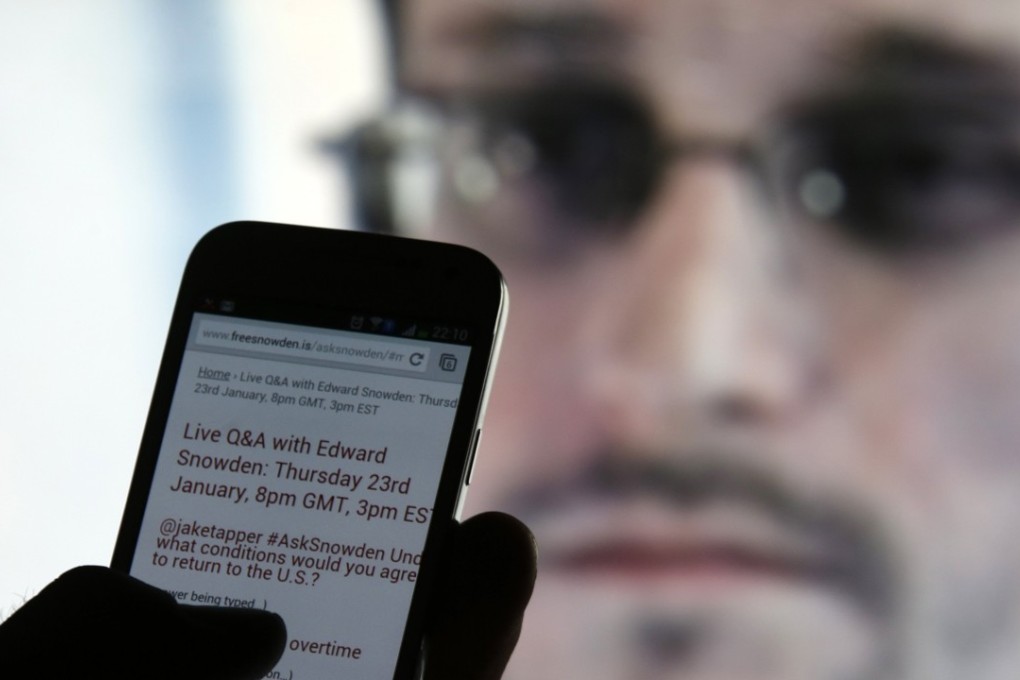 A man uses his mobile phone to read updates about former US spy agency contractor Edward Snowden. Photo: Reuters
