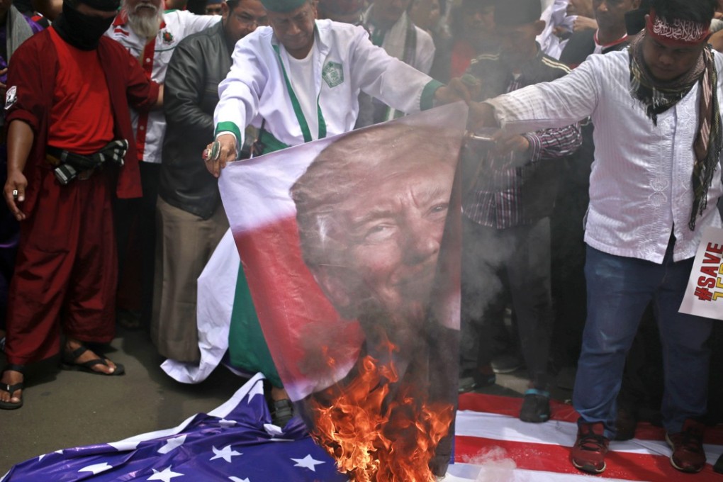 Protesters in Jakarta, Indonesia, burn a poster of US President Donald Trump during a rally outside US Embassy in the city, on December 11, to denounce Trump's decision to recognise Jerusalem as Israel's capital. Photo: AP