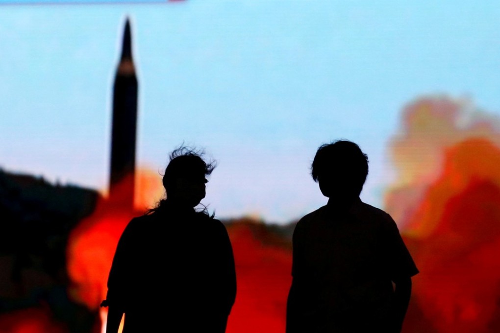 People walk in front of a monitor showing news of North Korea's latest missile launch in Tokyo in August. Photo: Reuters