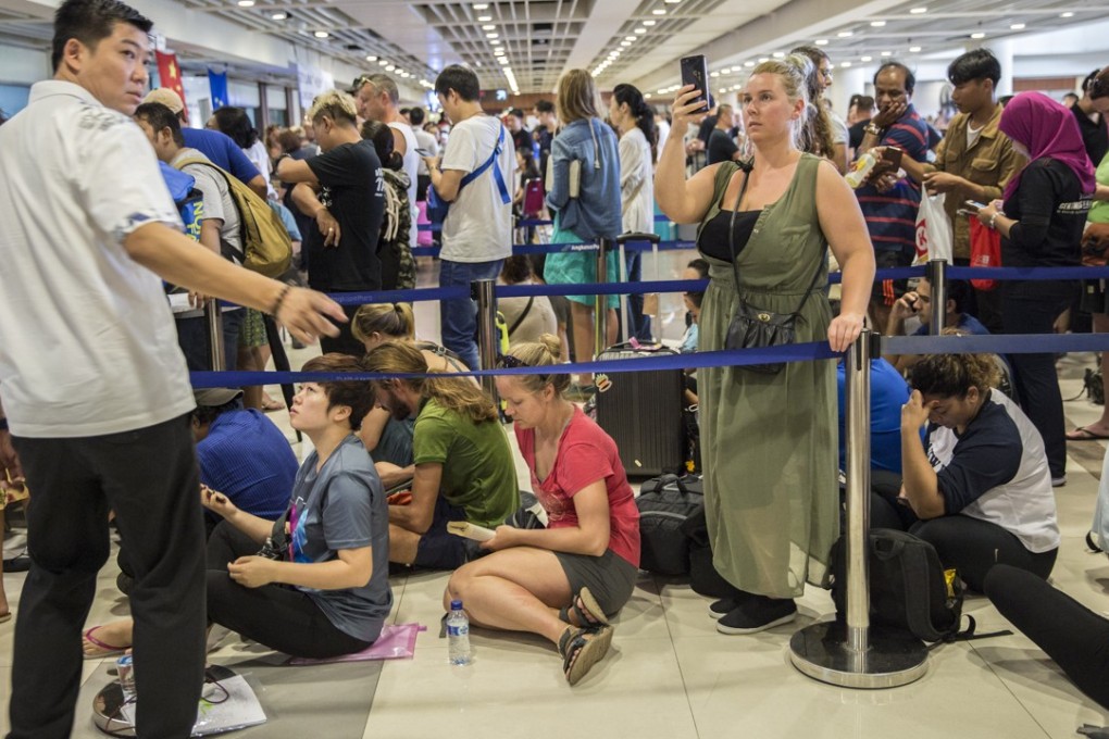 Passengers wait in line at a ticketing counter at Ngurah Rai International Airport near Denpasar, Bali, Indonesia. Weeks ago tourists were stranded by disruptions from the Bali volcano. Photo: Reuters