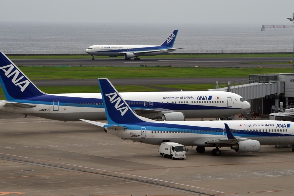 An All Nippon Airways (ANA) jetliner(back) rolls over for take off at Haneda International airport in Tokyo. Photo: AFP PHOTO/TOSHIFUMI KITAMURA
