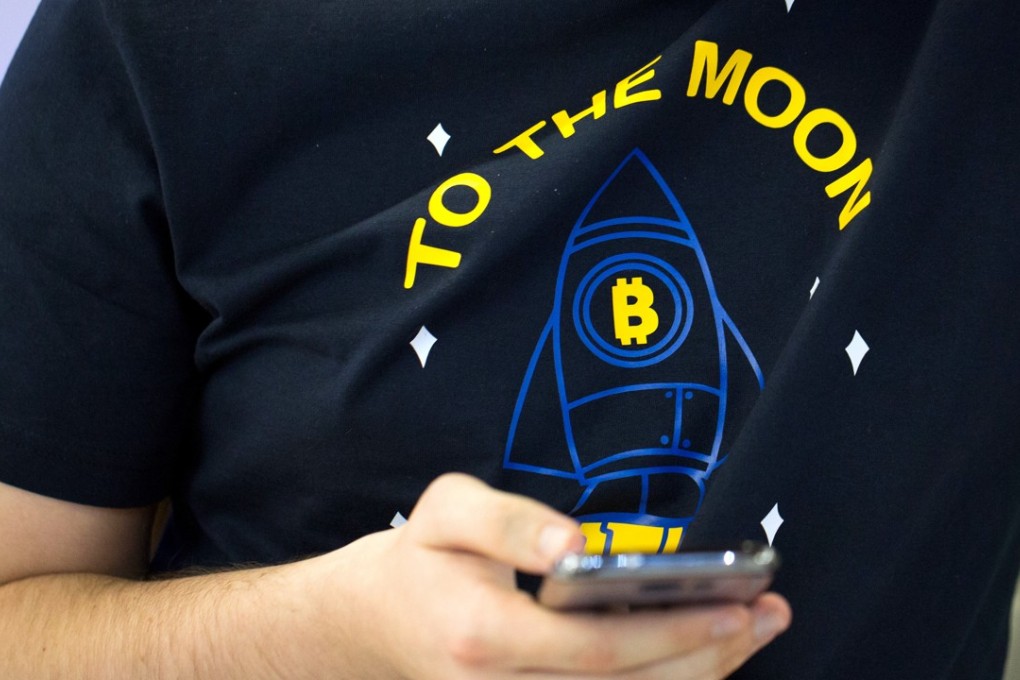 An attendee wearing a T-shirt decorated with a bitcoin rocket illustration and the words “To the Moon” checks his smartphone at the CrytoSpace conference in Moscow on December 8, eastern Europe's largest conference dedicated to blockchain technology and cryptocurrencies. Photo: Bloomberg