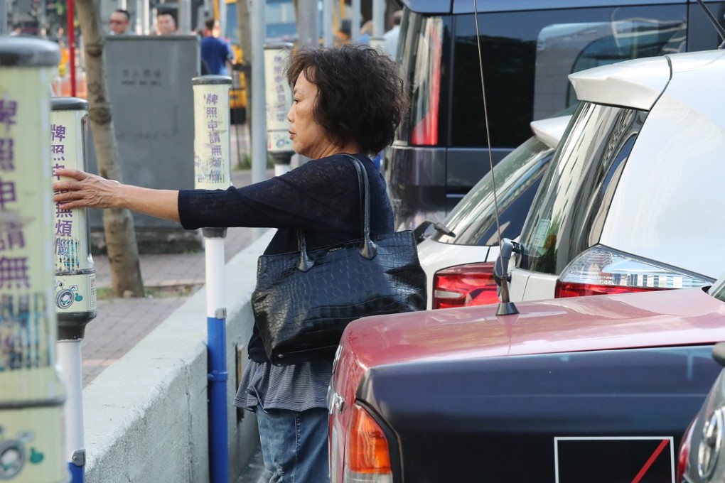 A woman pays for her parking fare in a parking meter at Victoria Park in Causeway Bay. Photo: K. Y. Cheng