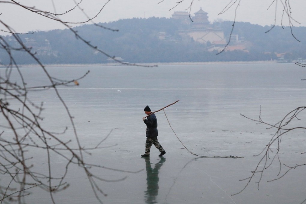 A worker walks across the frozen Kunming Lake at the Old Summer Palace in Beijing on Wednesday. Beijing topped the “green development” index but was second worst in a public satisfaction survey. Photo: Reuters