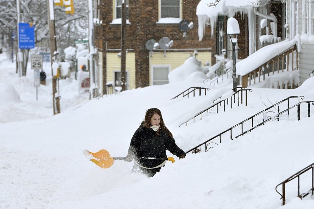 Rochelle Carlotti, 28, tries to clear snow from the steps of her home in Erie, Pennsylvania, on Tuesday after record snowfall. Photo: AP